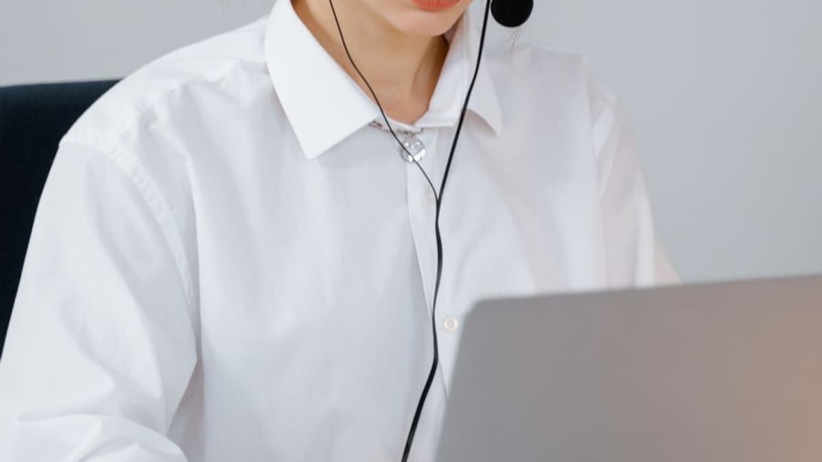 Atendente de headset trabalhando em um notebook